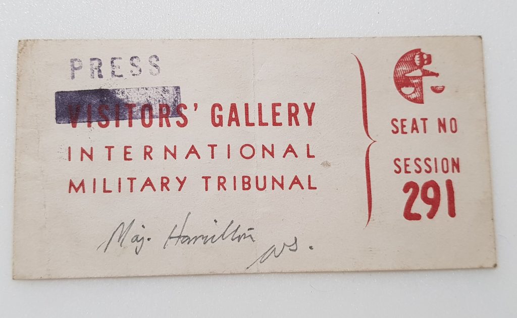 The front side of a press pass that gave entry to the court house during the Nuremberg Trials.  The text reads: Visitor's Gallery. International Military Tribunal. 'Visitor's' is blacked out, and above it is stamped the word 'Press'. Further text reads: Seat no. Session 291. A Major Hamilton has signed his name underneath the text.