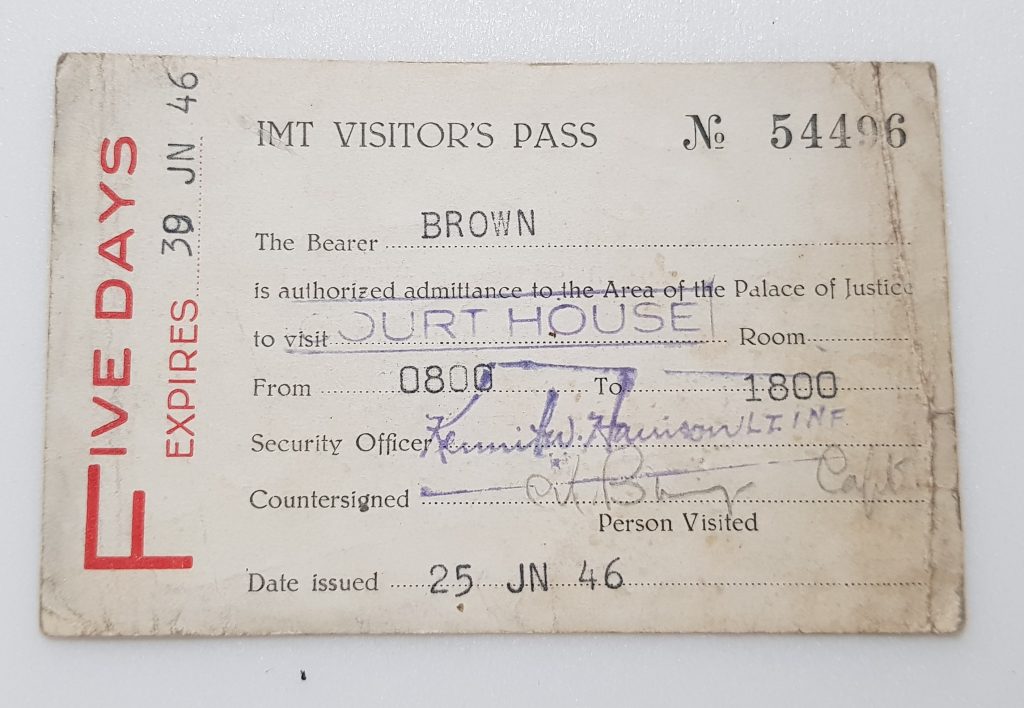 The back side of a press pass that gave entry to the court house during the Nuremberg Trials. The text reads: IMT Visitor's Pass. No 54496. The Bearer: Brown is authorized admittance to the Area of the Palace of Justice to visit COURTHOUSE (the word courthouse is stamped) from 0800 to 1800. Security Officer, followed by an unclear signature. Countersigned, followed by an unclear signature. Date issued: 25 JN 46. Along the left edge of the card, text reads: Five Days. Expires 30 JN 46